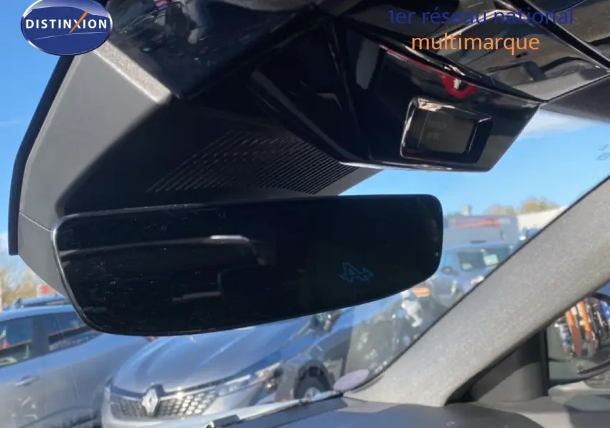 Rétroviseur intérieur noir avec logo Alpine, vue partielle du tableau de bord et extérieur avec Renault Austral blanc nacré.