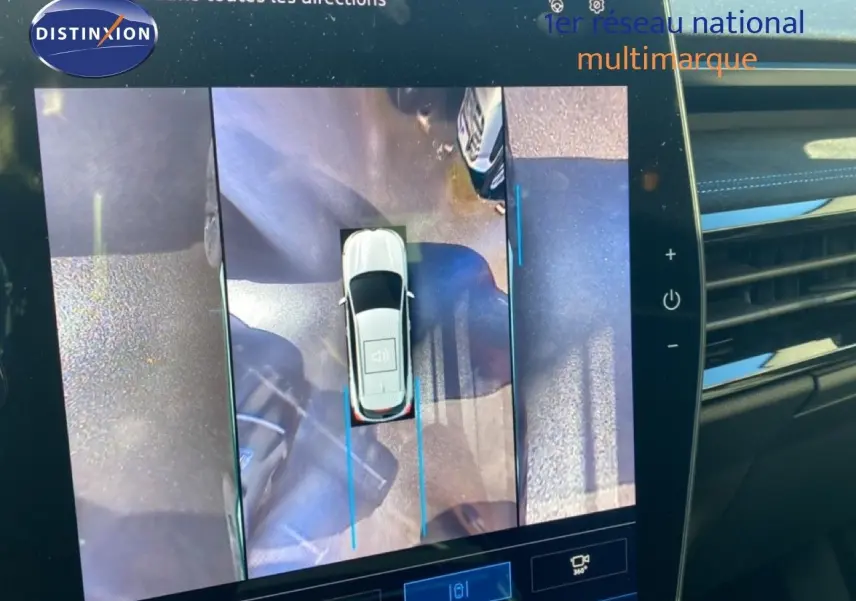 Vue intérieure de l'écran multimédia affichant la caméra 360° du Renault Austral blanc nacré toit noir en stationnement.