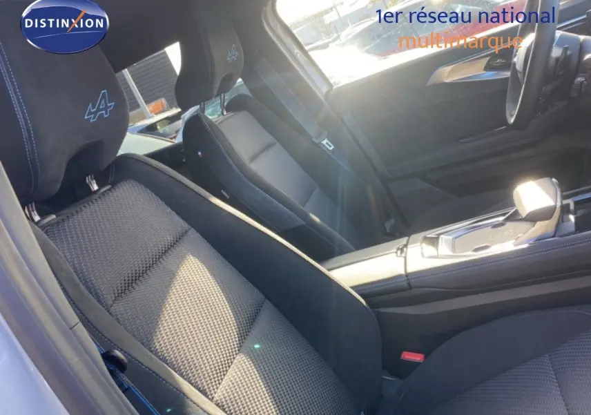 Vue intérieure du siège avant gauche en tissu et alcantara avec logo Alpine sur appuie-tête du Renault Austral blanc nacré.