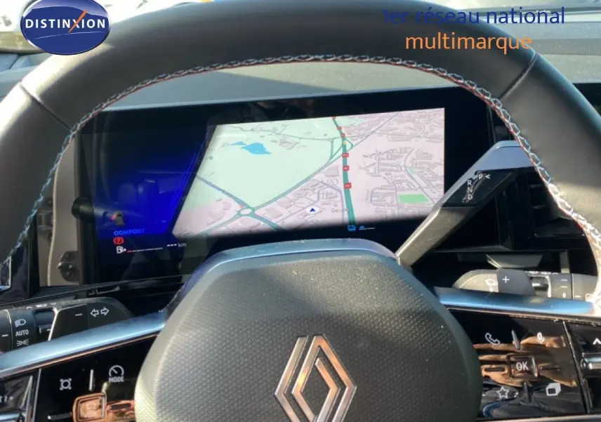 Vue rapprochée du volant et du tableau de bord numérique du Renault Austral blanc nacré avec toit noir, affichant la navigation.