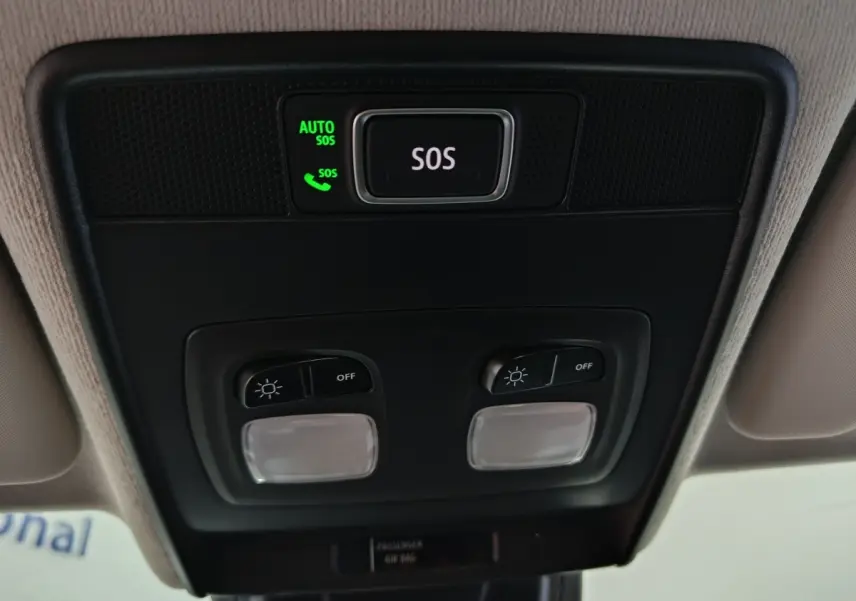 Vue en gros plan du plafonnier intérieur avec bouton SOS éclairé vert sur Renault Clio gris clair Evolution Blue dCi 100 2025.