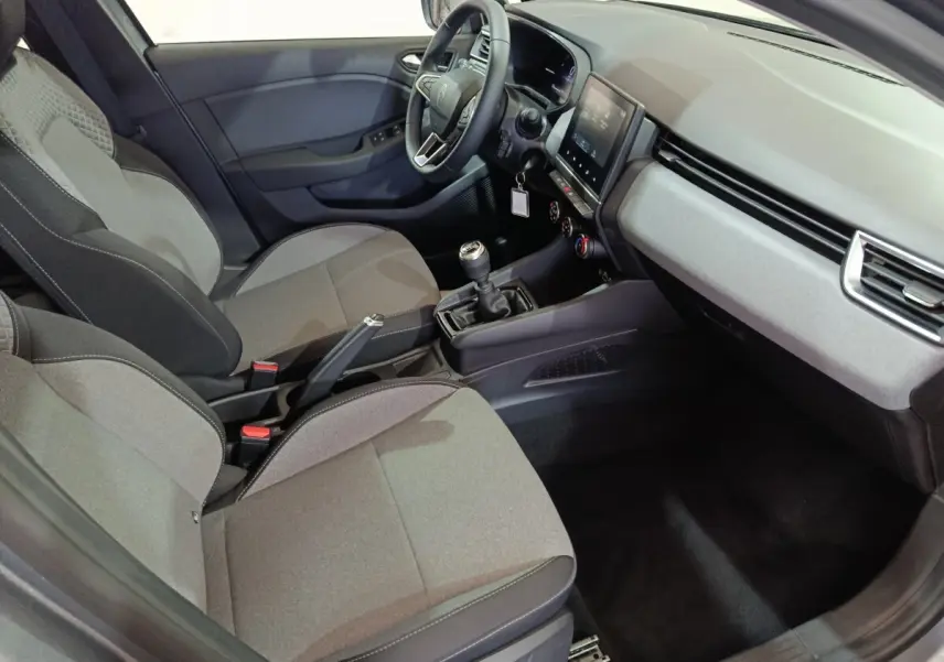 Vue intérieure côté conducteur de la Renault Clio gris clair 2025, avec tableau de bord moderne et boîte manuelle.
