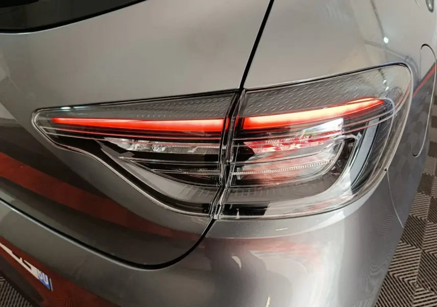 Gros plan sur le feu arrière droit allumé d'une Renault Clio gris clair Evolution Blue dCi 100 de 2025.
