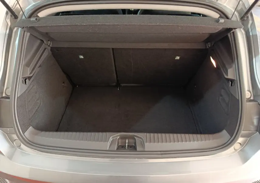 Coffre ouvert vu de l'arrière d'une Renault Clio gris clair, montrant l'espace de chargement et la tablette arrière.