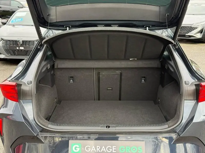 Vue arrière du coffre ouvert du CUPRA Formentor 1.5 eTSI Hybrid 2025 en gris magnétique mat, espace de chargement vide.