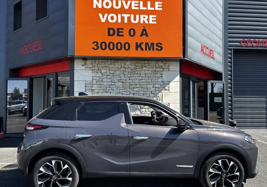 Vue latérale droite d'une DS3 1.2 PureTech 130 gris foncé, avec jantes alliage et toit noir contrasté.
