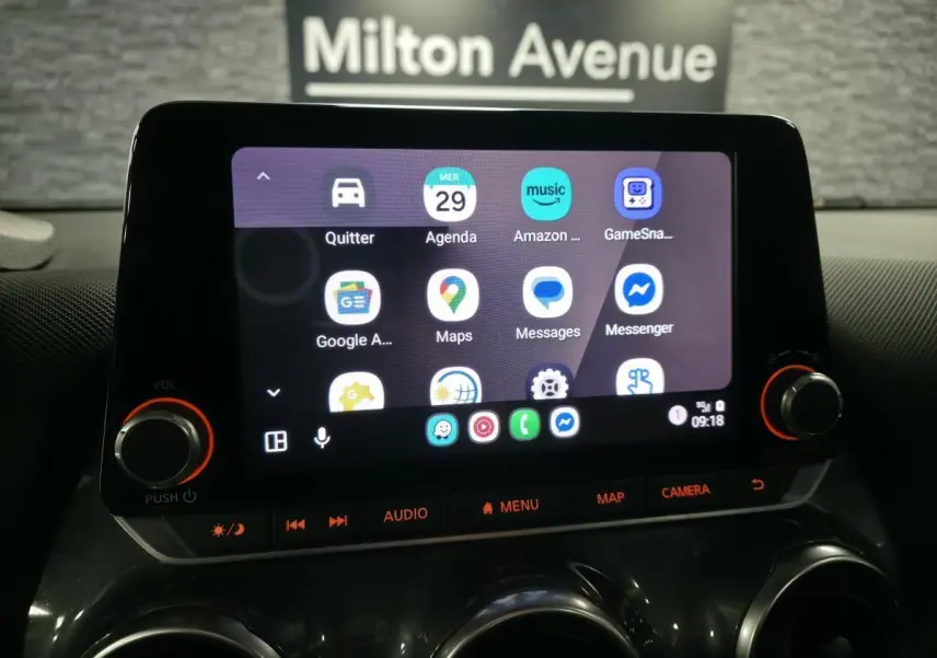 Écran tactile 8 pouces du Nissan Juke 2023 gris, vue rapprochée du tableau de bord avec commandes audio et navigation.
