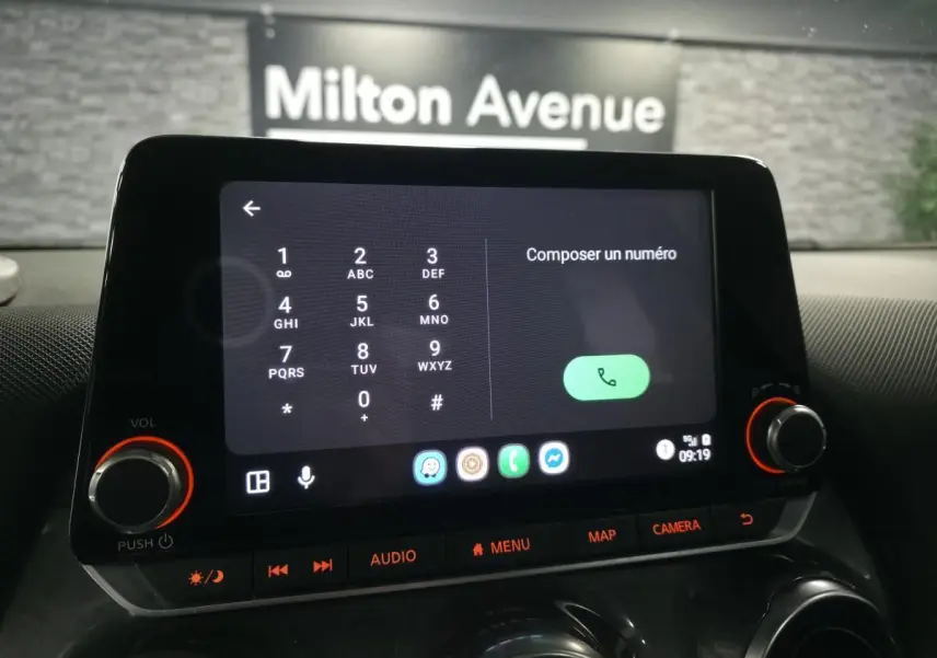 Écran tactile central du Nissan Juke 2023 affichant le clavier de composition, avec commandes audio et bouton caméra.