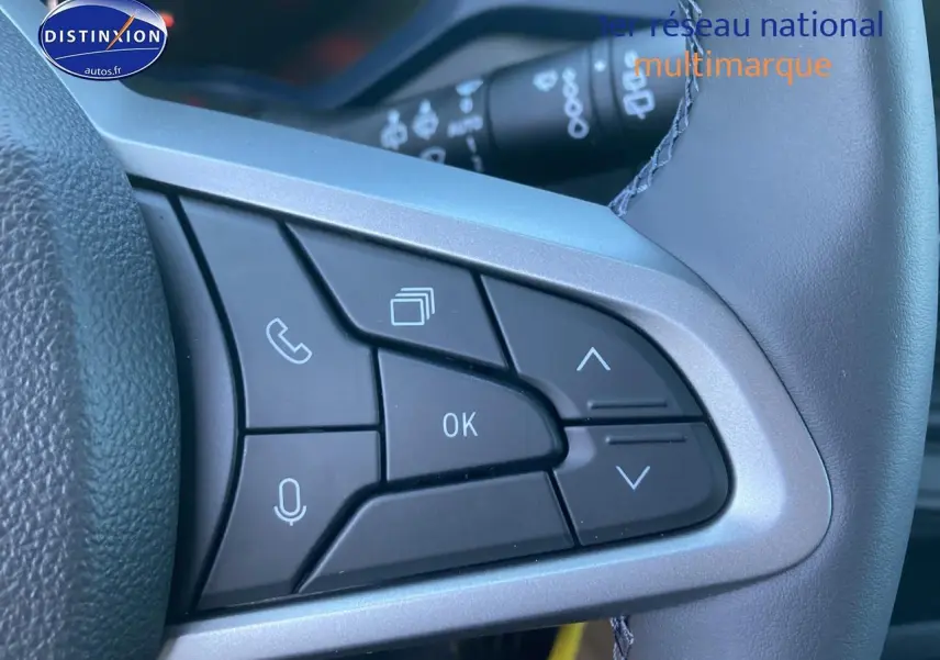 Gros plan sur les commandes multifonctions noires du volant côté droit du Dacia Duster noir 2025.