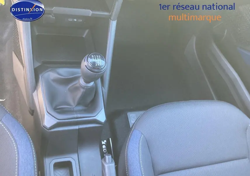 Vue intérieure centrée sur le levier de vitesses manuel et le siège avant droit du Dacia Duster noir 2025.