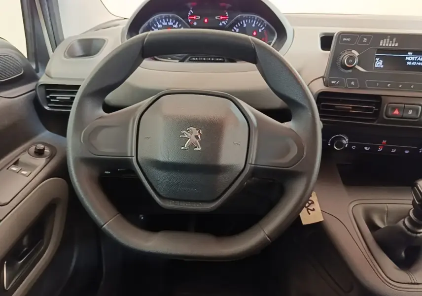 Vue intérieure centrée sur le volant noir du Peugeot Rifter 2020, avec tableau de bord et console centrale visibles.