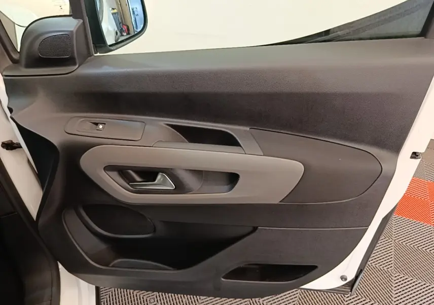 Vue intérieure de la porte avant gauche blanche du Peugeot Rifter 2020, avec poignée et commandes de vitre visibles.