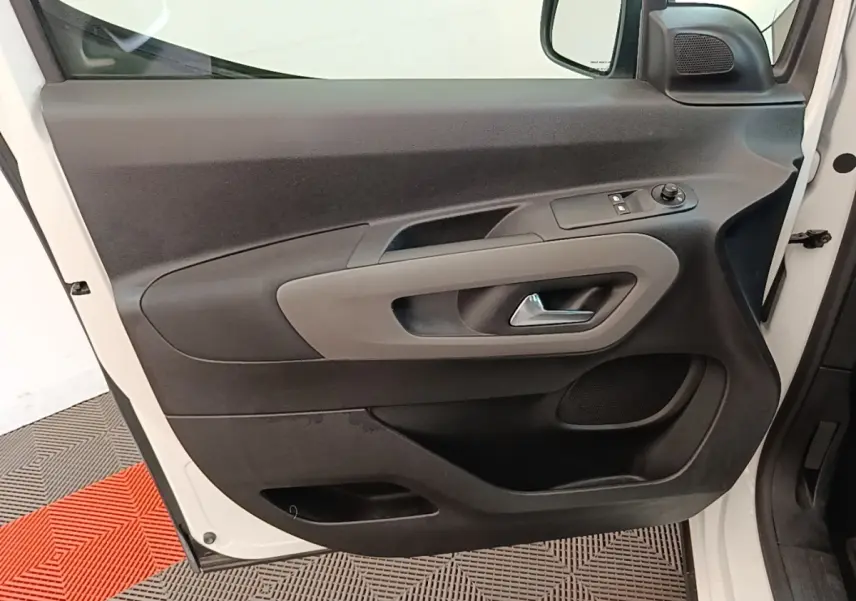 Vue rapprochée de la porte avant gauche blanche du Peugeot Rifter 2020, avec commandes électriques et poignée grise.