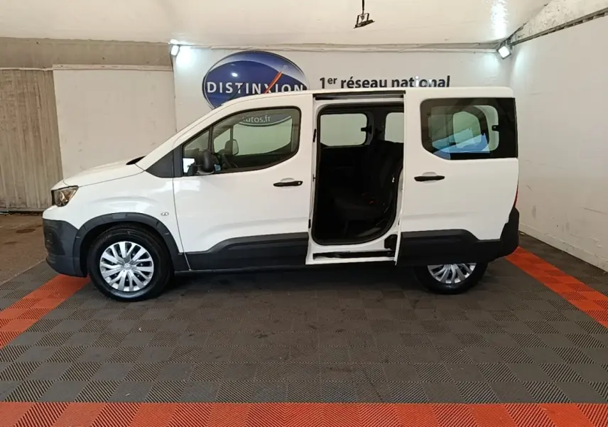 Peugeot Rifter blanc vue de profil droit avec porte coulissante arrière ouverte, intérieur sombre visible.