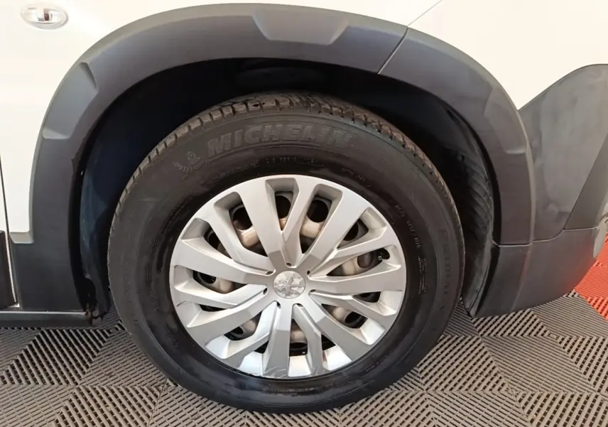 Gros plan sur la roue avant droite blanche du Peugeot Rifter 2020 avec jante argentée et pneu Michelin.
