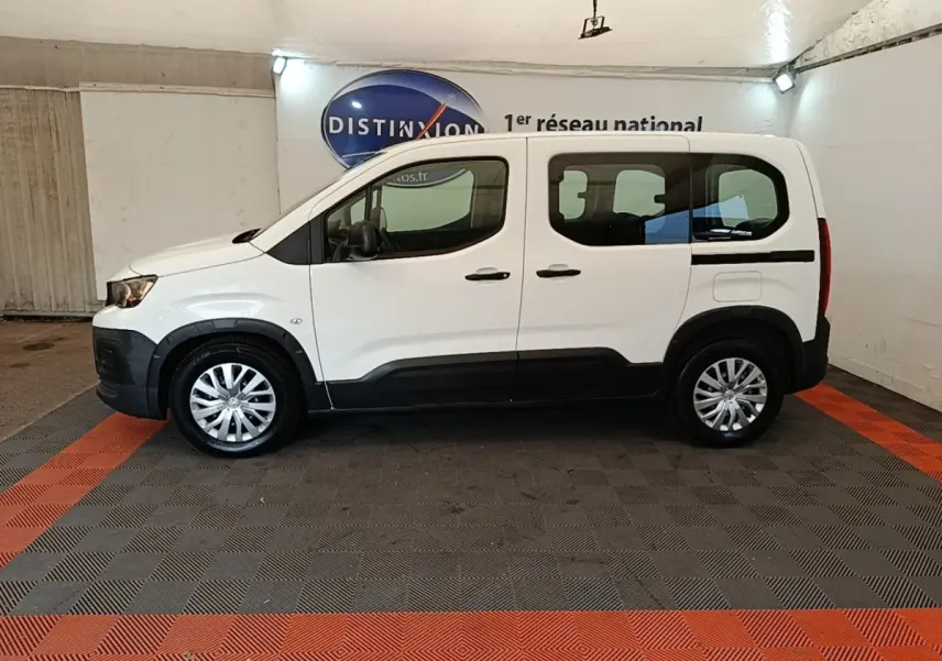 Peugeot Rifter blanc vue de profil côté gauche, avec protections noires sur les bas de caisse et jantes argentées.