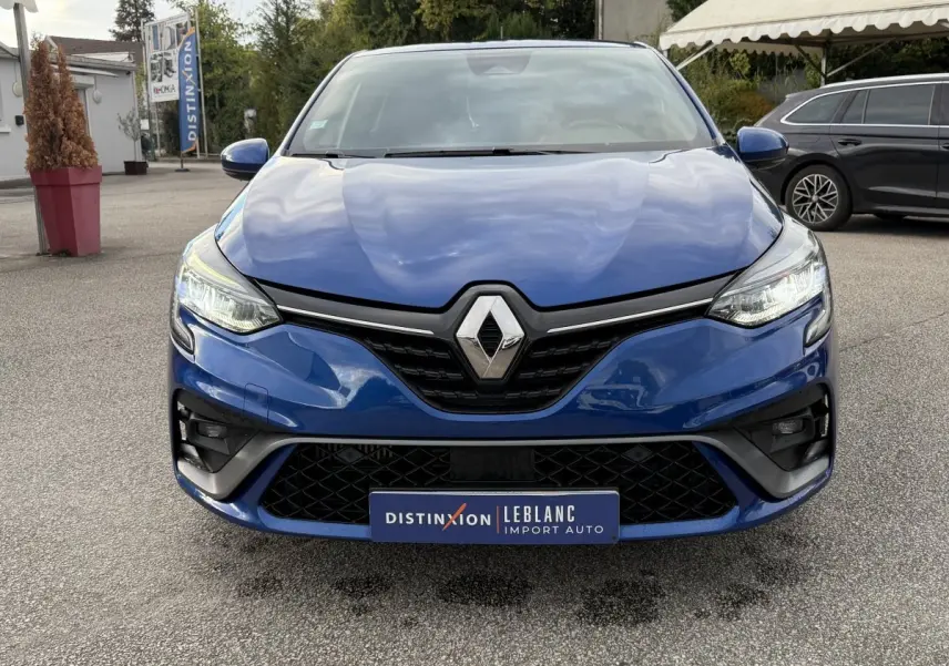 Vue frontale d'une Renault Clio RS Line bleu avec calandre noire et phares LED allumés.