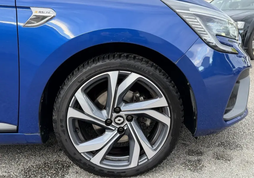 Gros plan sur la roue avant gauche d’une Renault Clio RS Line bleu 2021 avec logo RS Line sur l’aile.
