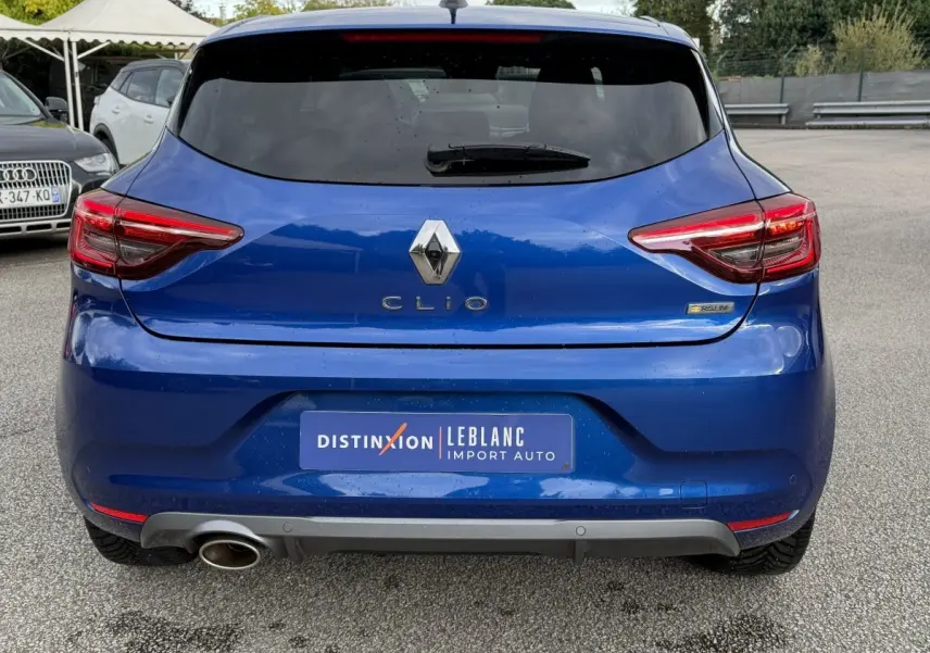 Vue arrière d'une Renault Clio RS Line bleu, avec feux LED et sortie d'échappement visible côté gauche.