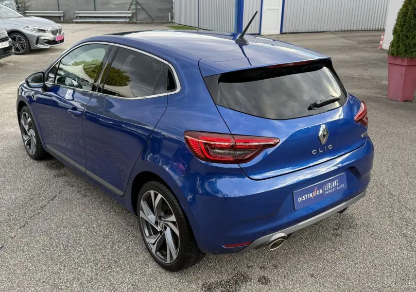 Vue 3/4 arrière droite d'une Renault Clio RS Line bleu 2021 avec jantes alliage et feux LED distinctifs.