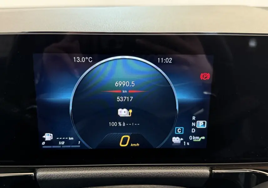 Affichage numérique du tableau de bord de la Mercedes GLA 250 e AMG Line 2023, montrant vitesse et autonomie batterie.