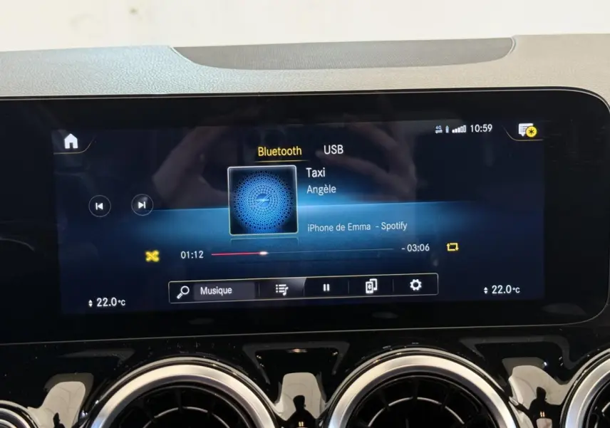 Écran tactile central de la Mercedes GLA 250 e AMG Line gris clair, affichant la musique via Bluetooth.
