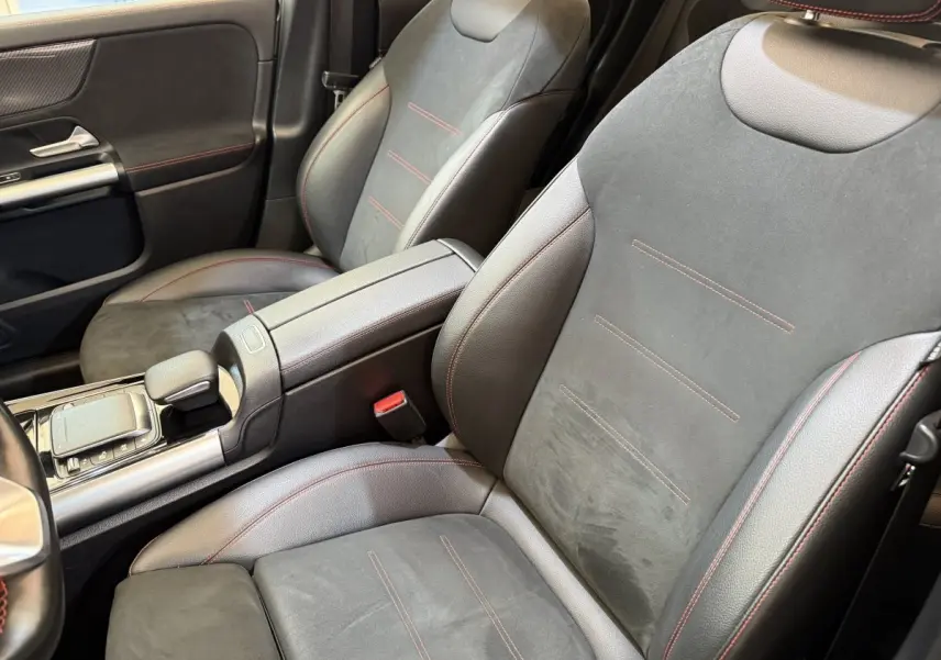 Vue rapprochée des sièges avant en cuir noir avec surpiqûres rouges dans l'habitacle du Mercedes GLA 250 e AMG Line 2023.