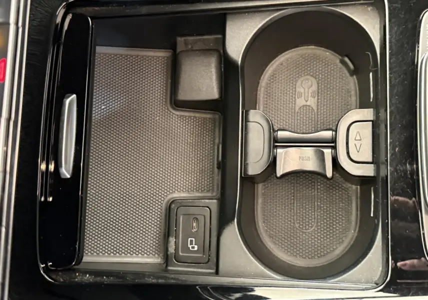 Vue rapprochée de la console centrale noire du Mercedes GLA 250 e AMG Line avec porte-gobelets et port USB-C.