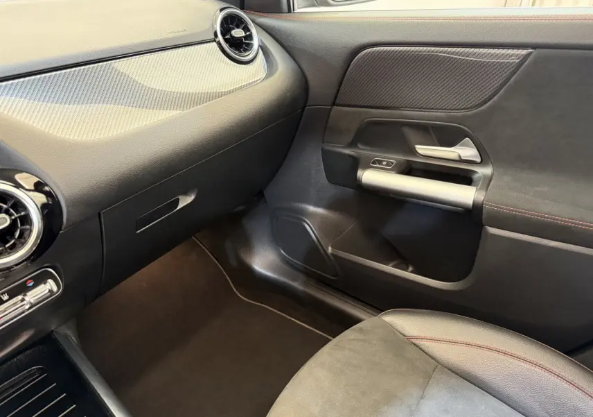 Vue intérieure côté passager du Mercedes GLA 250 e AMG Line 2023, avec tableau de bord noir et garnitures grises.