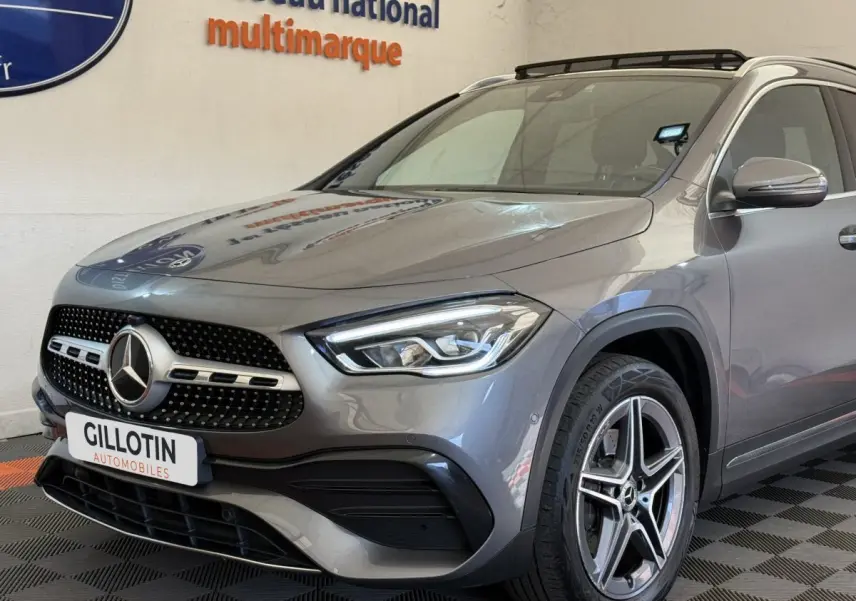 Mercedes GLA 250 e AMG Line gris clair vue 3/4 avant droit, avec calandre étoile et jantes alliage cinq branches.