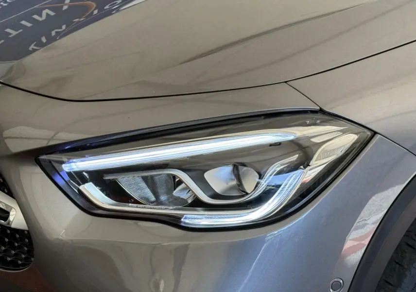Gros plan sur le phare avant droit LED d’un Mercedes GLA 250 e AMG Line gris clair, soulignant ses lignes modernes.
