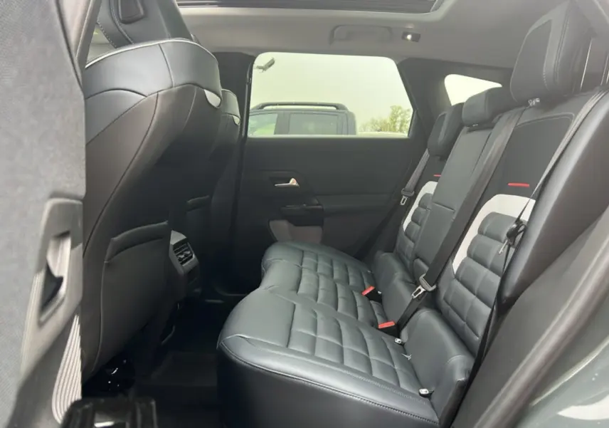 Vue latérale intérieure des sièges arrière en cuir noir matelassé du Citroën C5 Aircross New Hybrid 2026 avec toit ouvrant panoramique.