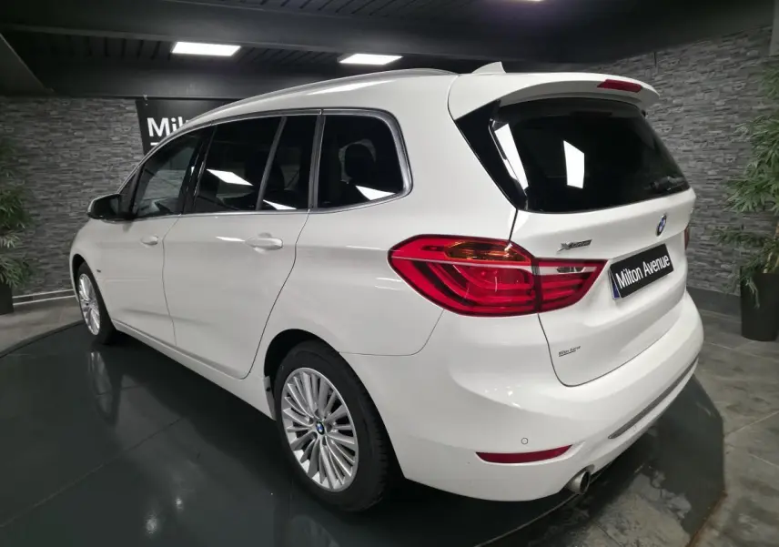 BMW Série 2 Gran Tourer blanc vue 3/4 arrière droit, avec jantes alliage et badge xDrive visible sur le hayon.