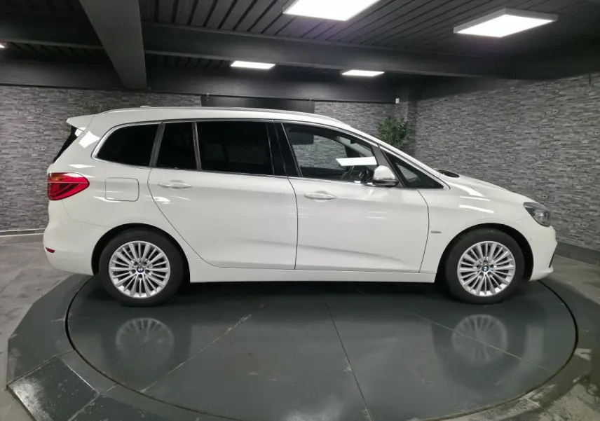 Vue latérale droite d'une BMW Série 2 Gran Tourer blanche avec jantes alliage 17'' et vitres teintées.