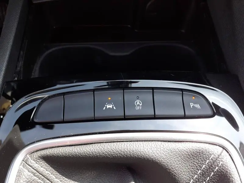 Détail intérieur des commandes d’aide à la conduite sur la console centrale d’une Opel Insignia Grand Sport 2021.