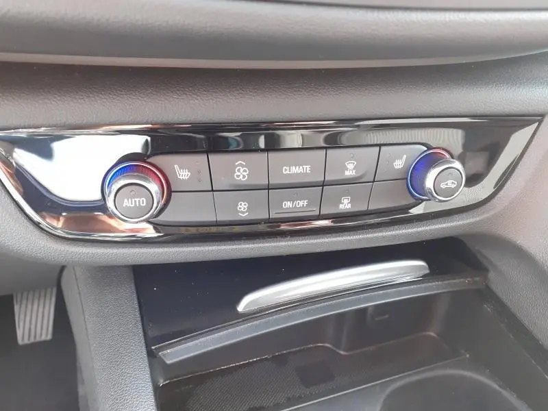 Panneau de commande de climatisation de l’Opel Insignia Grand Sport 2021, vue rapprochée du tableau de bord noir brillant.