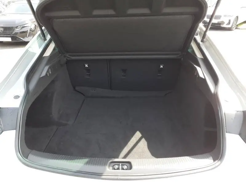 Vue ouverte du coffre spacieux et propre de l'Opel Insignia Grand Sport gris clair, version 2021, sans chargement visible.