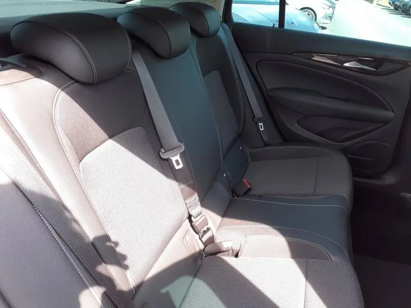 Vue intérieure côté droit des sièges arrière gris clair de l’Opel Insignia Grand Sport 2021 avec ceinture de sécurité visible.