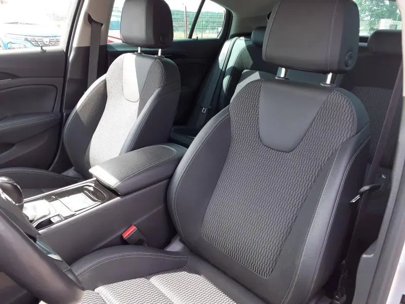 Vue intérieure de l’Opel Insignia Grand Sport 2021 montrant les sièges avant en tissu gris avec accoudoir central.