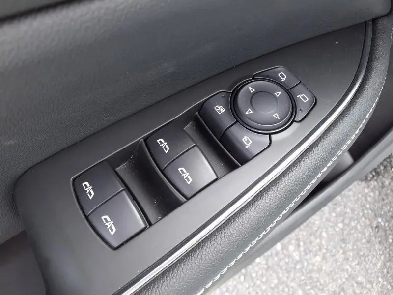Gros plan sur les commandes de lève-vitres et rétroviseurs côté conducteur de l’Opel Insignia Grand Sport gris clair 2021.
