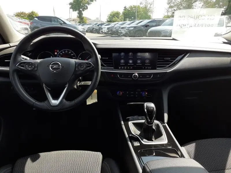 Vue intérieure de l’Opel Insignia Grand Sport 2021, tableau de bord et volant noirs avec levier de vitesse manuel.