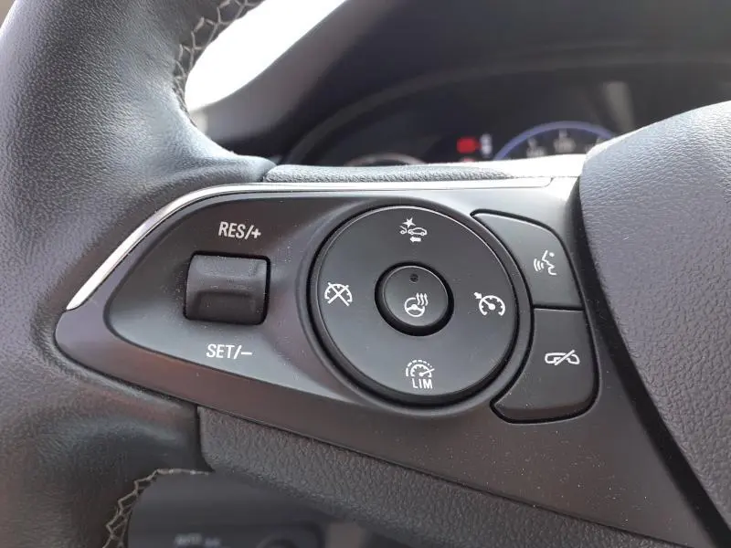 Gros plan sur les commandes au volant de l’Opel Insignia Grand Sport 2021, boutons de régulateur et assistant de conduite.