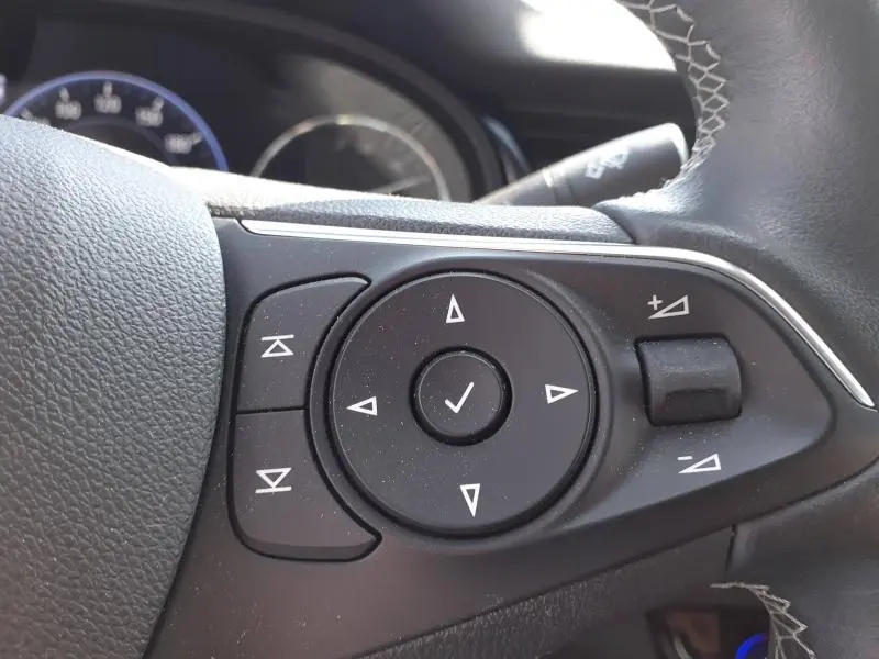 Gros plan sur les commandes multifonctions à droite du volant de l'Opel Insignia Grand Sport gris clair 2021.