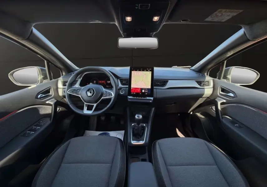 Vue intérieure avant du Renault Captur Techno TCe 90 2024, tableau de bord gris avec écran tactile vertical et volant multifonctions.