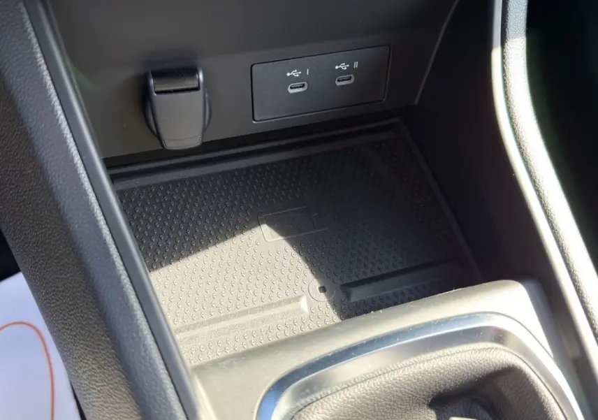 Gros plan sur la console centrale du Renault Captur gris foncé, montrant les ports USB-C et prise 12V.
