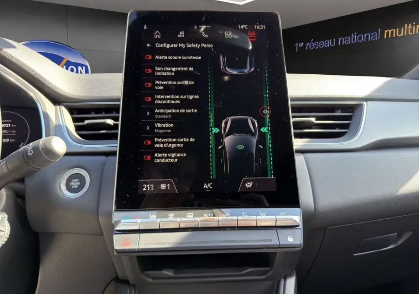 Vue intérieure du tableau de bord du Renault Captur gris foncé 2024 avec écran tactile central affichant l'aide à la conduite.