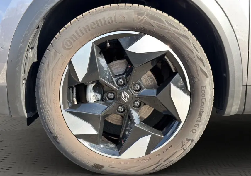Gros plan sur la roue avant droite du Renault Captur gris foncé 2024 avec jante noire et argentée au design géométrique.