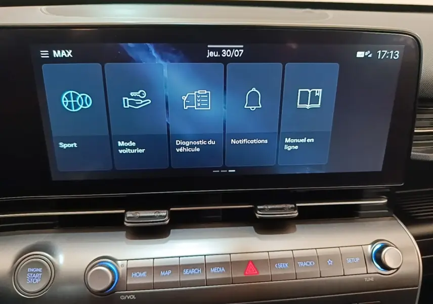 Écran tactile central du tableau de bord du Hyundai Kona 2024 affichant les modes Sport, Mode voiturier et notifications.