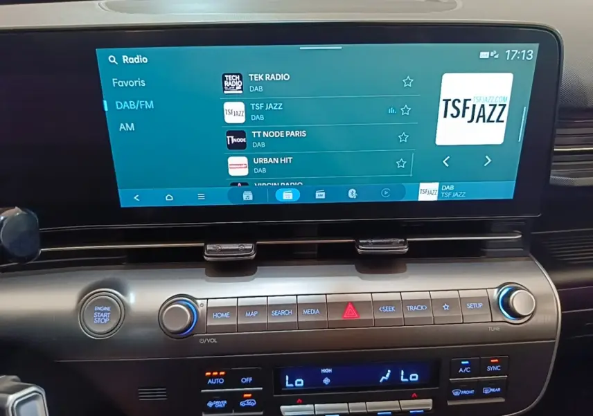 Vue rapprochée de l’écran tactile central et des commandes du tableau de bord du Hyundai Kona 1.6 Hybrid vert 2024.
