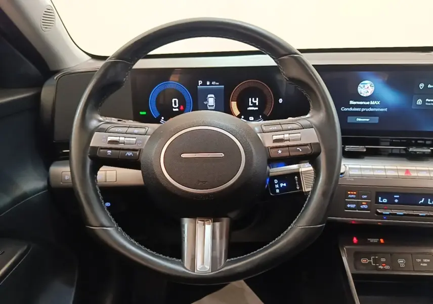 Vue intérieure centrée sur le volant cuir et le tableau de bord numérique du Hyundai Kona 1.6 Hybrid 2024.